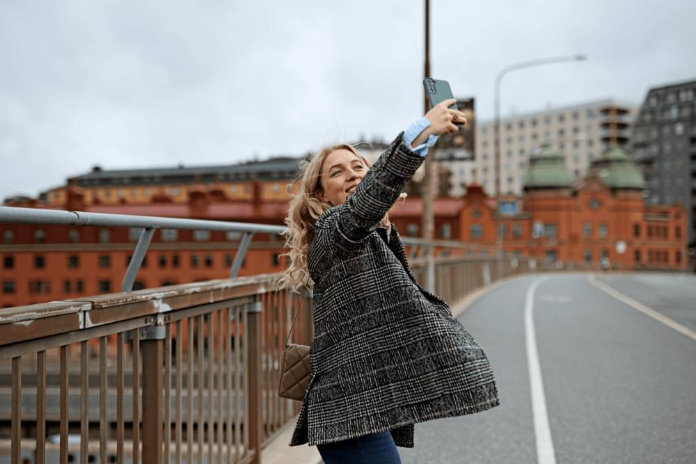 Kvinna tar en selfie med mobilen utomhus